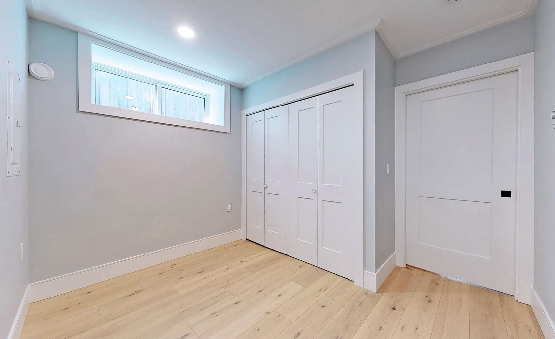 basement level bedroom with closet and small window in lightwell