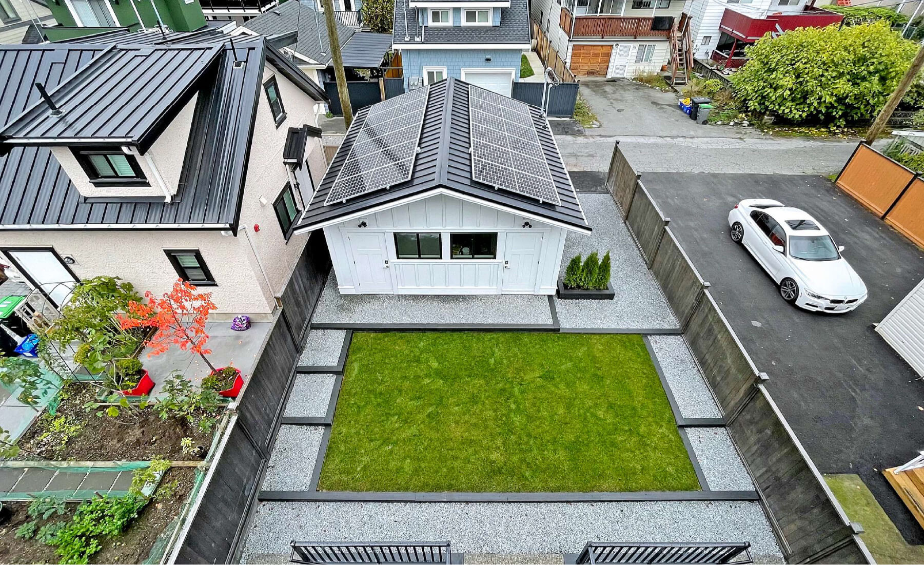 detached garage with solar panels by alley of duplex
